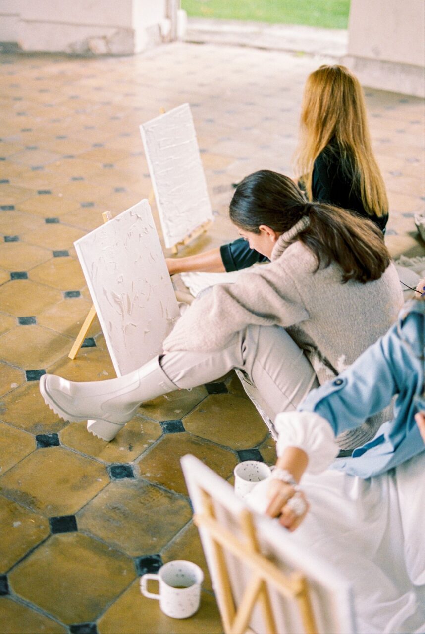 Varias mujeres trabajando sobre lienzos durante una actividad artística compartida